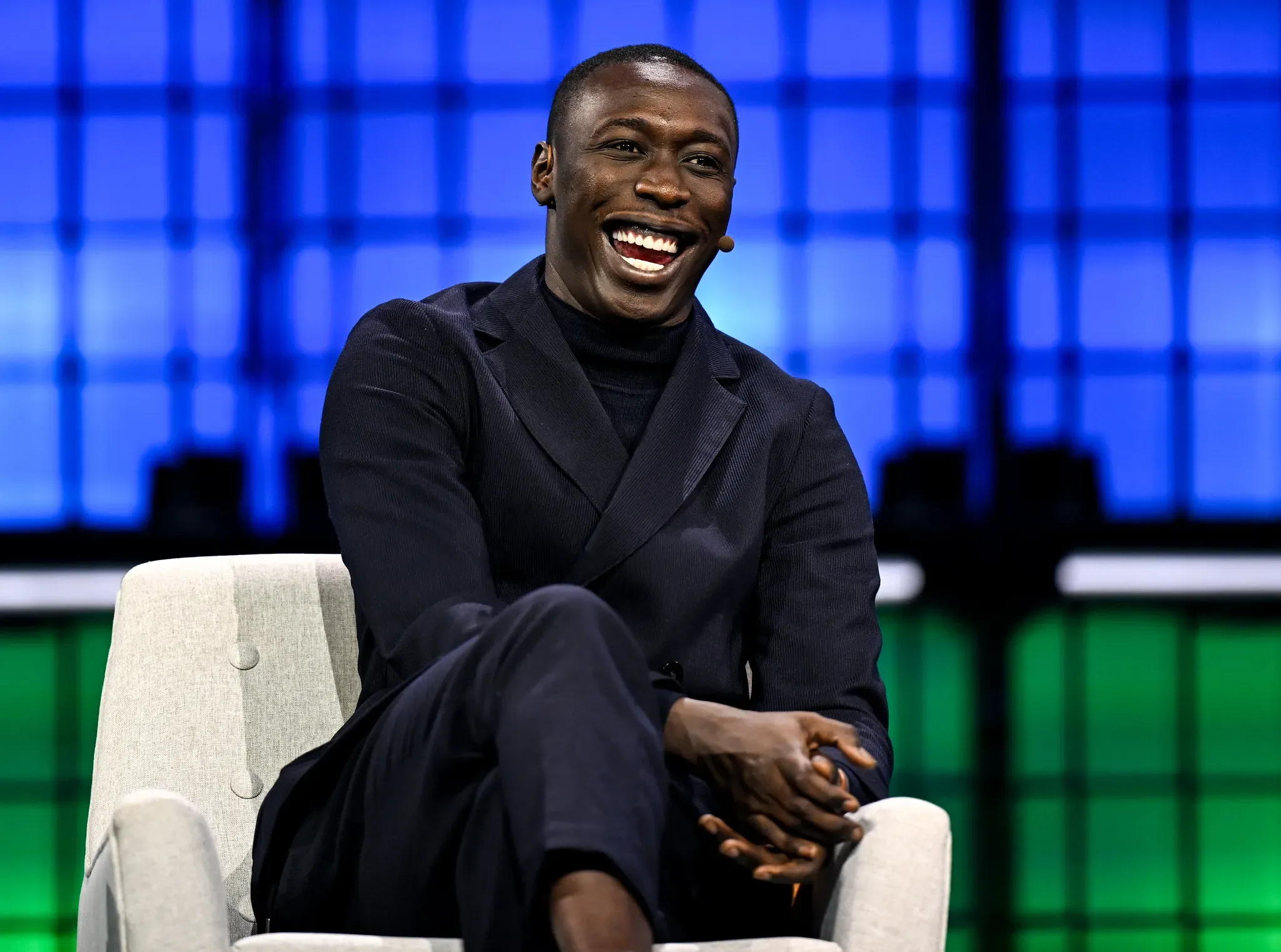 TikTok star and entrepreneur Khaby Lame smiles during a public appearance, embodying the success of African creators building global brands. He exemplifies influence transforming into serious business.